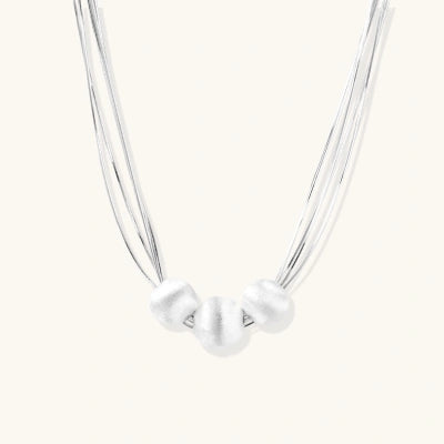 Silver Thread Necklace necklaces photographed for VENIER on a warm ivory product set