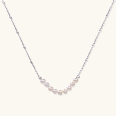 Smile Arc Pearl Necklace necklaces photographed for VENIER on a warm ivory product set