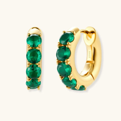 Emerald Huggie Hoops earrings photographed for VENIER on a warm ivory product set